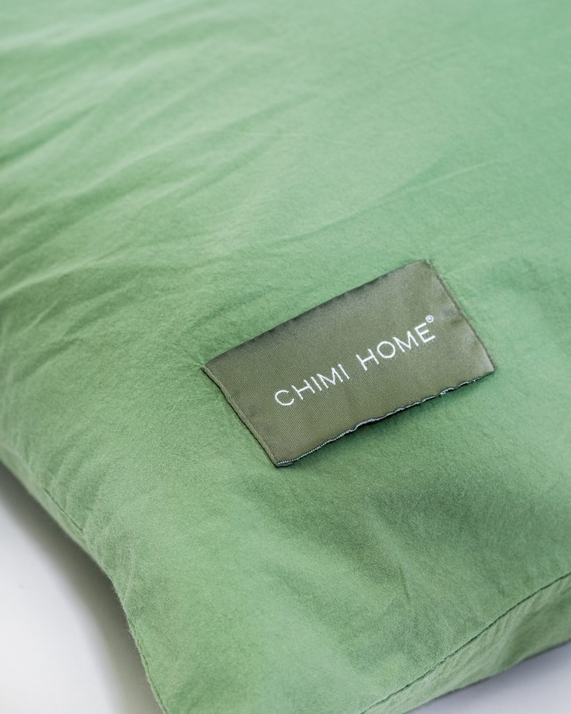 gröna-sängkläder-produktbild-chimi-home-örngott-närbild-logga-rainbow-collection
